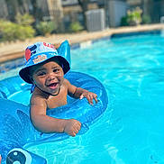 Messiah joined the competition — help win amazing prizes! toddler, child, smiling, pool, water, inflatable_ring, hat, summer, outdoor, swimming, fun, happy, baby, blue, sunlight, vacation, floating, playful, water_toys, leisure