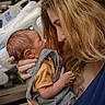 affection, baby, bed, child, closeup, clothing, emotion, face, hand, holding, hospital, hospital_room, love, newborn, parent, person, portrait, skin, tenderness, woman