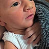 Finnick is registered to the contest to win money with this photo: baby, blanket, child, close_up, curious, cute, expression, face, hand, human, indoors, infant, newborn, portrait, skin, sleepy, soft_texture, tender, white_clothing, young