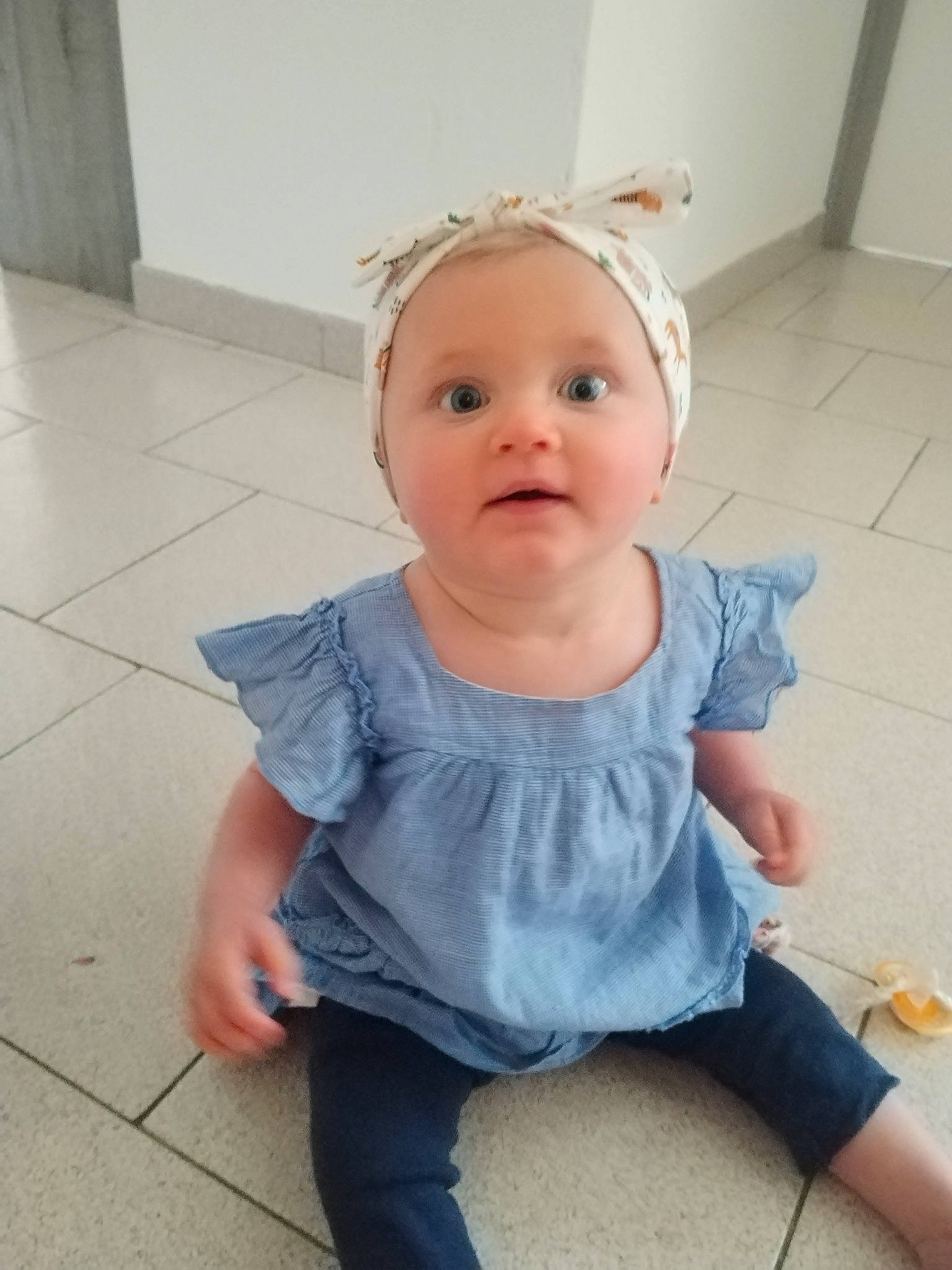 Mïa a rejoint le concours — aidez-le/la à gagner de superbes lots ! baby, baby_toddler_clothing, cheek, child, chin, eyelash, face, flooring, hairstyle, happy, hat, headband, iris, pattern, person, shoulder, sitting, skin, sleeve, t_shirt