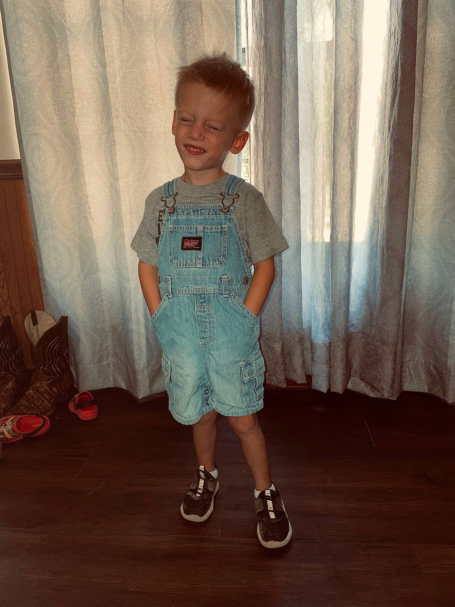 Linton is registered to the contest to win money with this photo: arm, baby_toddler_clothing, curtain, denim, floor, flooring, hair, happy, head, human_body, joy, knee, neck, person, shoe, shoulder, sleeve, smile, standing, t_shirt