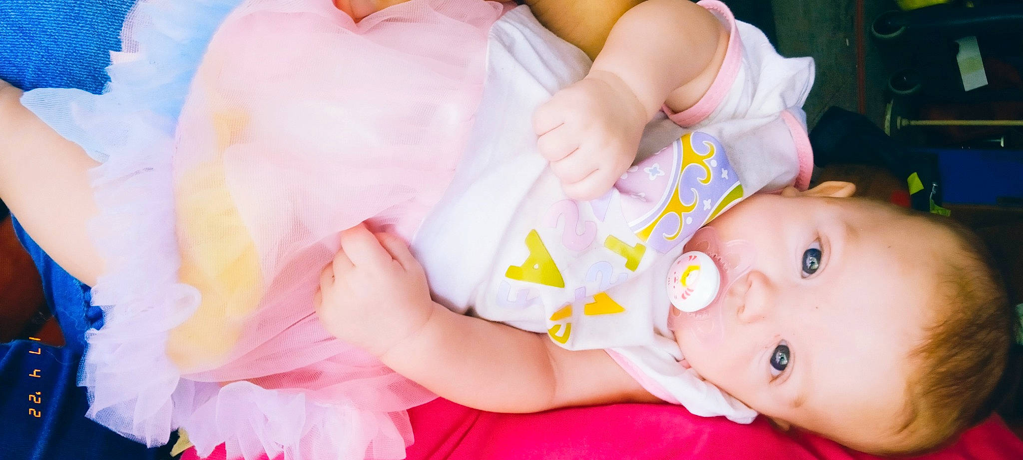 Allie is registered to the contest to win money with this photo: baby, baby_toddler_clothing, comfort, finger, gesture, hand, happy, headgear, human_body, leg, mouth, muscle, neck, nose, orange, person, pink, skin, textile, toddler