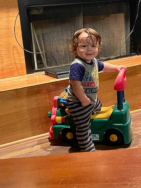 Hayden is registered to the contest to win money with this photo: baby, baby_toddler_clothing, child, flooring, fun, hardwood, joy, motor_vehicle, person, plastic, play, riding_toy, rolling, sitting, smile, tire, toddler, toy, toy_vehicle, vehicle