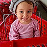baby, child, smiling, shopping_cart, retail_store, target_store, gray_hat, towel_turban, pink_shirt, portrait, face, blue_eyes, indoors, outdoors, storefront, red_cart, sitting, infant, happy, photography