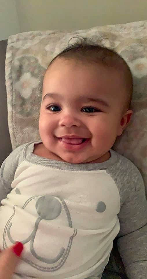 Ermys is registered to the contest to win money with this photo: baby, baby_toddler_clothing, cheek, child, chin, comfort, eyebrow, eyelash, happy, iris, joy, linens, lip, mouth, nose, person, skin, sleeve, smile, t_shirt