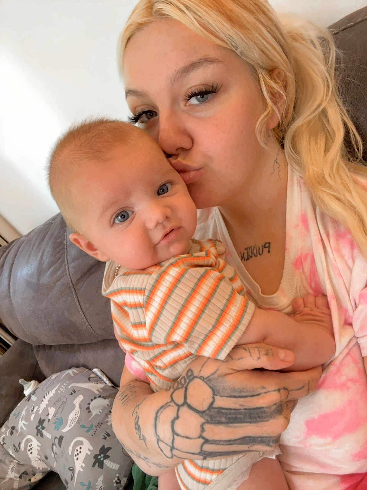 Kaisen joined the competition — help win amazing prizes! baby, woman, tattoo, kiss, couch, striped_clothing, indoor, person, child, blue_eyes, blonde_hair, love, affection, pillow, dinosaur_pattern, casual, close_up, portrait, holding, family
