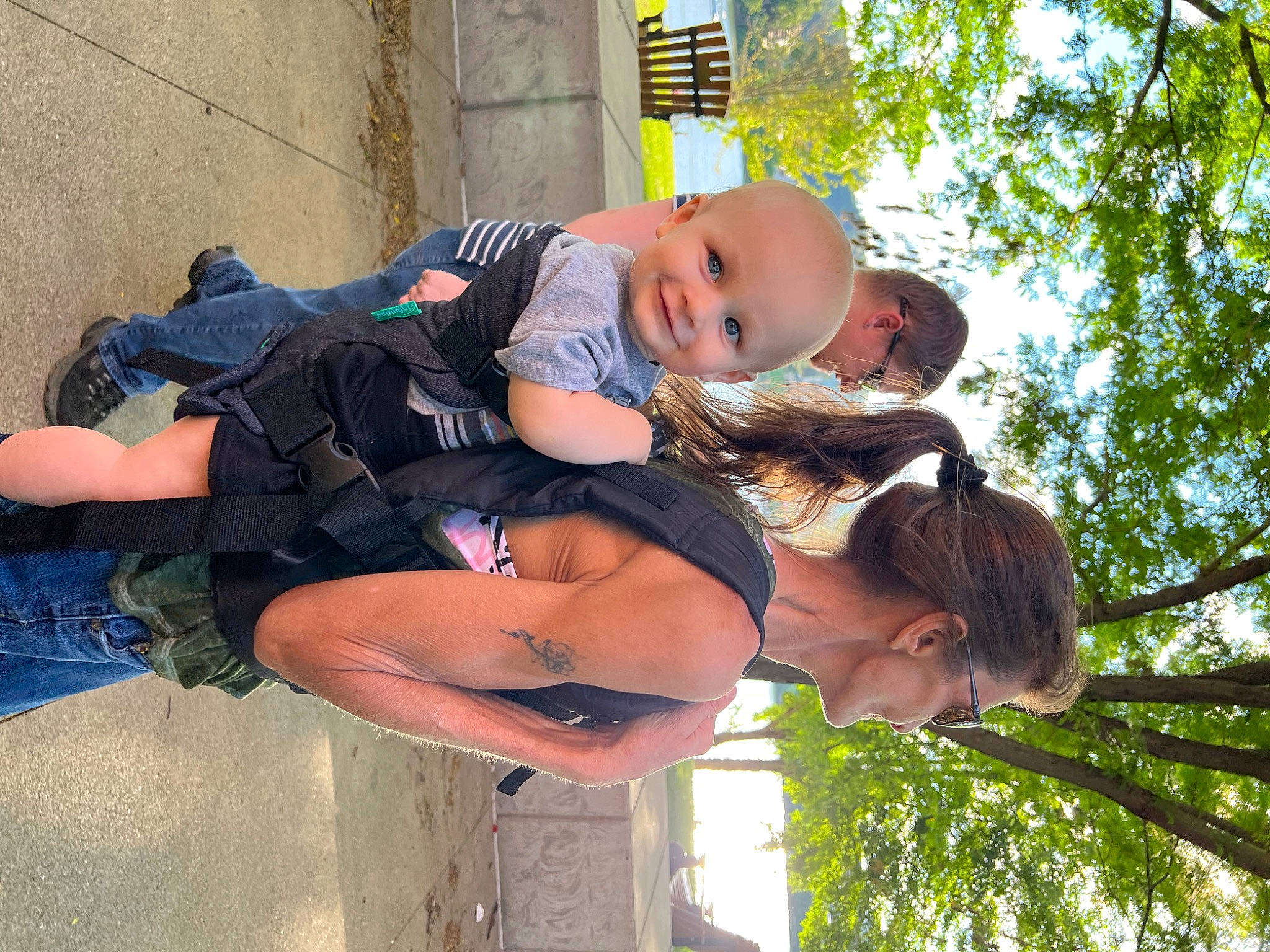 Brendon is registered to the contest to win money with this photo: baby, child, eyewear, fun, gesture, grass, happy, hat, hug, joy, leisure, people_in_nature, person, plant, recreation, shorts, sky, sunglasses, toddler, tree