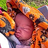 baby, infant, sleeping, portrait, face, closed_eyes, blanket, tiger_pattern, orange, black, pink_clothing, stroller, outdoor, garden, sunlight, cozy, peaceful, resting, close_up, child