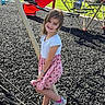 Sophia is registered to the contest to win money with this photo: child, girl, smiling, playground, outdoor, play_equipment, rope, balancing, slide, climbing_net, park, sunny, grass, rubber_mulch, dress, pink, sneakers, portrait, happy, daylight