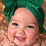 baby, child, smile, face, headband, green_bow, cute, closeup, portrait, happy, cheeks, eyes, pink_clothing, infant, joyful, cute_expression, adorable, bokeh, soft_light, earrings