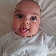 Eliza participe au concours pour gagner de l'argent avec cette photo : baby, infant, face, tongue_out, white_clothing, closeup, cute, smiling, lying_down, soft_texture, cheeks, eyes, head, expression, newborn, child, adorable, portrait, sleepwear, fabric