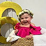baby, child, smile, flower_crown, pink_clothing, basket, blanket, indoor, happy, cute, portrait, celebration, number_6, floor, woven_basket, toddler, person, head, face, joy