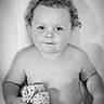 baby, child, curly_hair, blanket, knitted, smile, portrait, black_and_white, cute, innocence, soft_lighting, sitting, young_child, toddler, hand, face, expression, skin, indoors, cozy