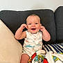 Wyatt joined the competition — help win amazing prizes! baby, blanket, child, clothing, colorful, comfort, couch, cute, face, happy, home, indoor, infant, onesie, person, pillow, playful, relaxation, seated, smiling