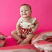 Wyatt joined the competition — help win amazing prizes! baby, child, smile, pink_background, balloons, cute, happy, portrait, infant, sitting, clothing, red_hearts, one_person, studio, celebration, playful, young_child, indoors, fashion, colorful