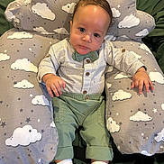 Ajion is registered to the contest to win money with this photo: baby, infant, child, cushion, cloud_pattern, green_pants, striped_shirt, bow_tie, socks, indoor, portrait, cute, relaxing, seated, fabric, soft_toy, small_hands, big_eyes, comfortable, casual_clothing