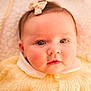 baby, infant, child, portrait, close_up, eyes, headband, bow, sweater, yellow_clothing, collar, button, blanket, soft_lighting, warm_tone, chubby_cheeks, cute, looking_at_camera, newborn, skin
