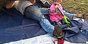 Aubrianna is registered to the contest to win money with this photo: child, toddler, person, adult, car, ford_mustang, vehicle, jack_stand, tool, outdoor, grass, gravel, jeans, pink_clothing, repair, mechanic, play, sitting, working, daylight