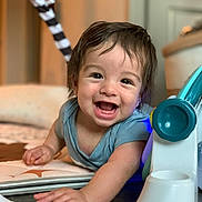Lincoln Frey is registered to the contest to win money with this photo: baby, smiling, happy, play_mat, indoor, child, toy, cute, infant, person, face, reaching, blue_clothing, floor, closeup, young_child, home, bright_eyes, wet_hair, playtime