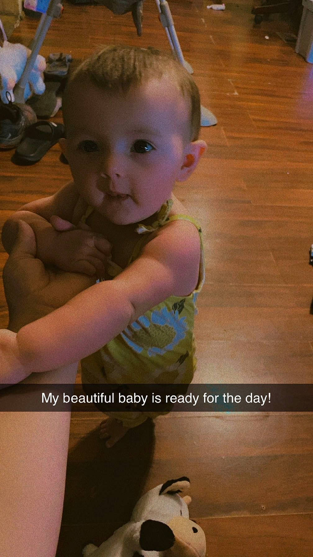 Zoe is registered to the contest to win money with this photo: baby, baby_toddler_clothing, cheek, child, eye, finger, floor, flooring, fun, hair, happy, hardwood, head, human_leg, iris, leg, person, skin, smile, toddler