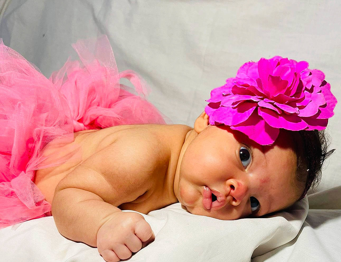 Jenna participe au concours pour gagner de l'argent avec cette photo : arm, baby, baby_toddler_clothing, child, comfort, costume_hat, dress, eyelash, fashion_accessory, finger, hair_accessory, headband, headpiece, human_body, magenta, person, petal, pink, plant, skin