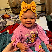 Kaelani joined the competition — help win amazing prizes! baby, bed, blanket, child, clothing, cozy, curtains, cute, hand, happy, indoor, person, pink_outfit, portrait, smiling, toddler, warm, window, winnie_the_pooh, yellow_bow