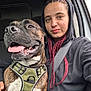 Shyrkan Malaise participe au concours pour gagner de l'argent avec cette photo : dog, person, car, seatbelt, hoodie, smile, happy, pet, window, leash, brown_dog, indoor, closeup, companion, casual, young_adult, seat, daylight, friendly, portrait
