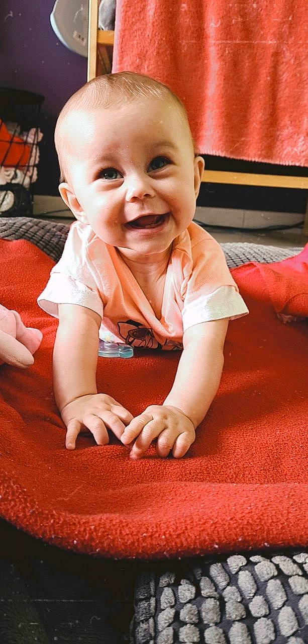Syana participe au concours pour gagner de l'argent avec cette photo : baby, baby_toddler_clothing, cheek, chin, comfort, eye, facial_expression, finger, floor, flooring, happy, head, iris, mouth, nose, orange, person, skin, sleeve, smile