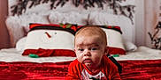 Ethan joined the competition — help win amazing prizes! baby, infant, red_clothing, blanket, bed, pillow, snowman, holiday, christmas, decor, face, person, indoors, cozy, cute, expression, plush, festive, child, toddler