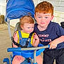 Ethan joined the competition — help win amazing prizes! child, toddler, tricycle, outdoor, porch, baby, blue, play, smiling, person, clothing, footwear, hair, sitting, standing, toy, helmet, hand, face, window