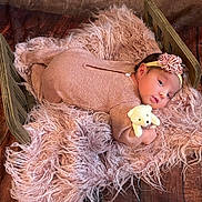 Elizabeth joined the competition — help win amazing prizes! baby, infant, teddy_bear, headband, flower, blanket, wooden_bed, pink_outfit, soft_texture, fur, floor, cute, portrait, child, lying_down, indoor, newborn, cozy, toy, sleepwear