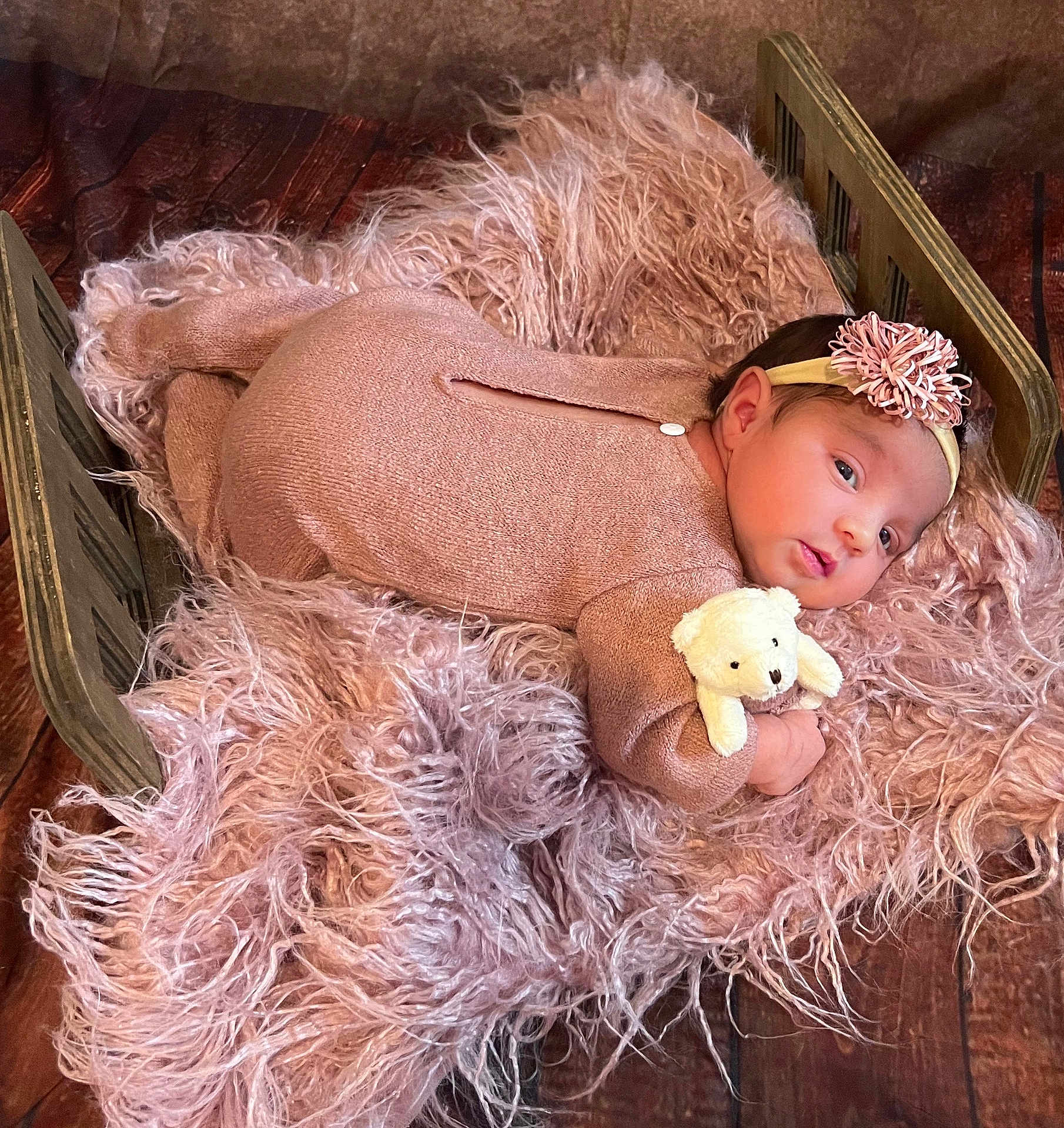 Elizabeth joined the competition — help win amazing prizes! baby, infant, teddy_bear, headband, flower, blanket, wooden_bed, pink_outfit, soft_texture, fur, floor, cute, portrait, child, lying_down, indoor, newborn, cozy, toy, sleepwear