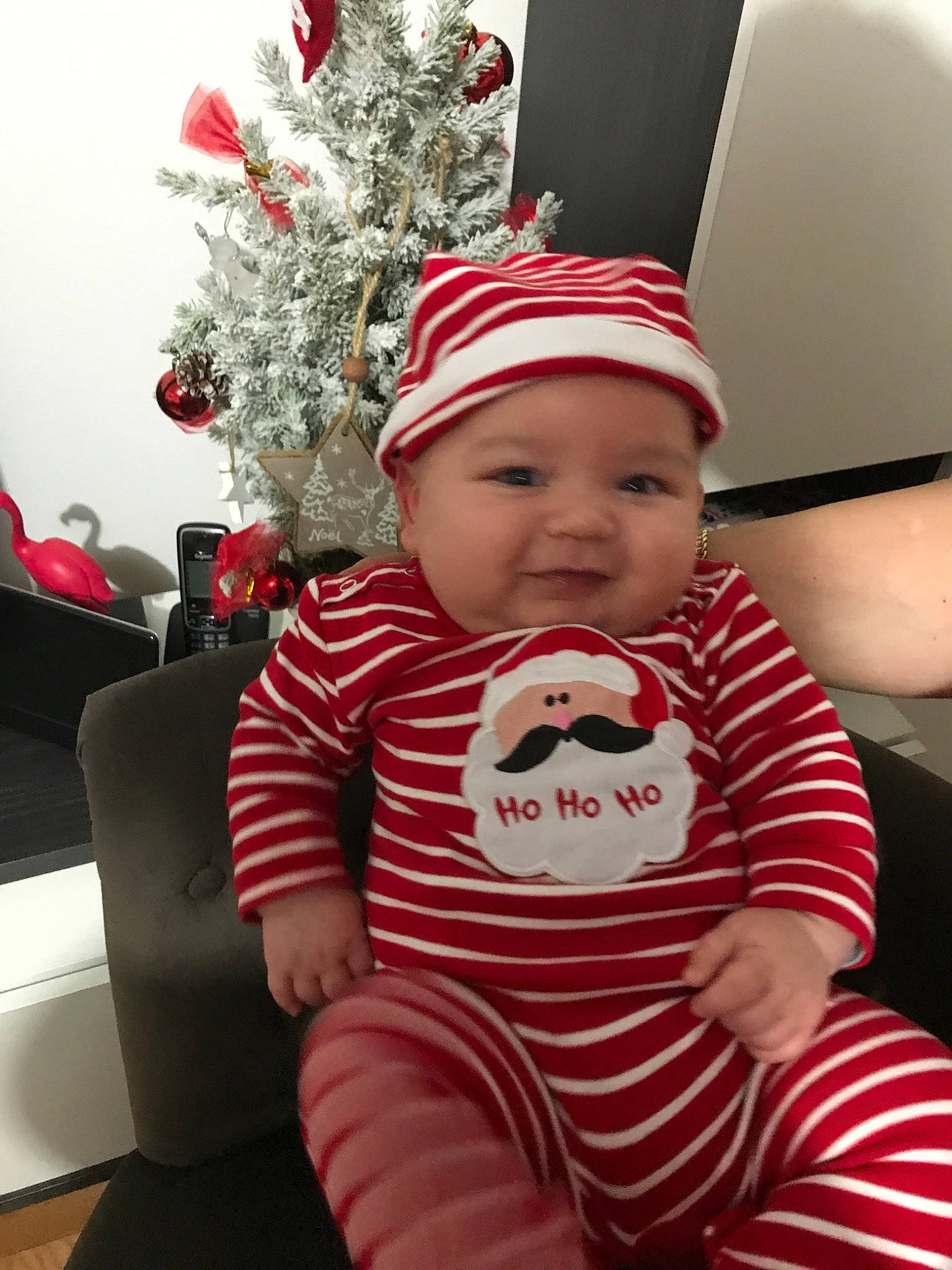 Kaél participe au concours pour gagner de l'argent avec cette photo : baby, child, christmas, christmas_eve, electronic_device, event, fictional_character, fun, happy, headgear, headwear, holiday, person, red, sitting, toddler