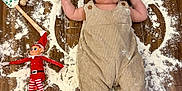 Ale is registered to the contest to win money with this photo: baby, floor, flour, overalls, elf_doll, toy, wood, baking_tools, rolling_pin, spatula, messy, child, indoors, playful, cute, infant, person, smiling, hands_up, foot