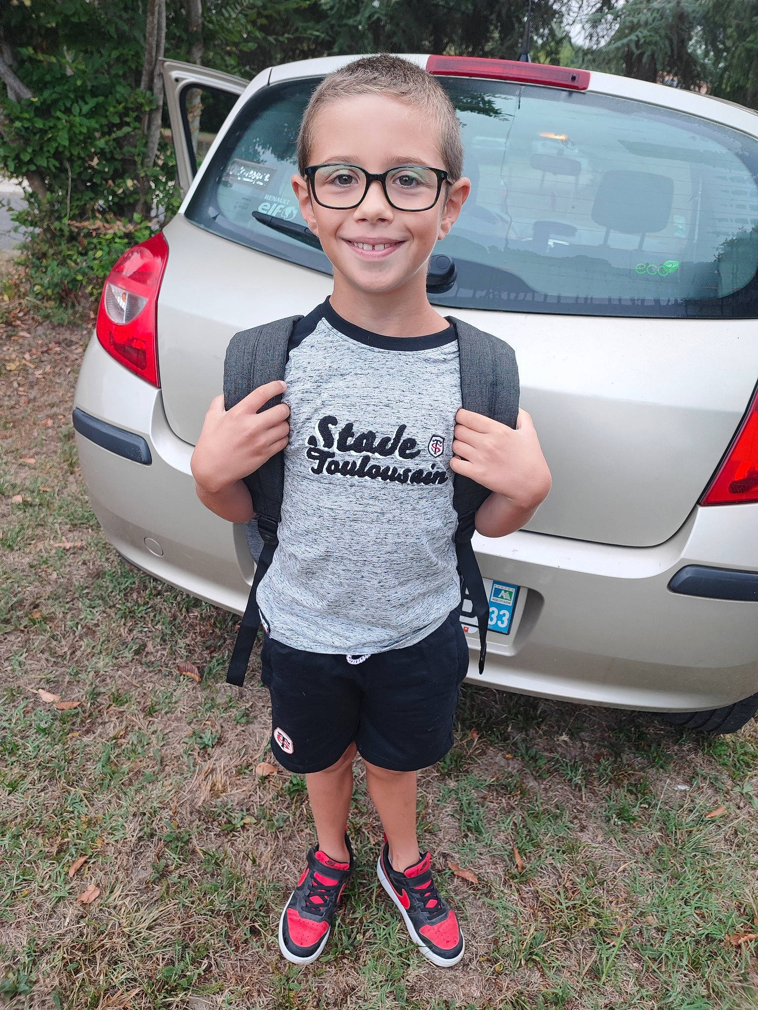 Nathan a rejoint le concours — aidez-le/la à gagner de superbes lots ! automotive_design, automotive_exterior, automotive_lighting, automotive_tire, bumper, car, glasses, hood, joy, land_vehicle, leisure, motor_vehicle, person, plant, recreation, shorts, smile, tree, trunk, vehicle