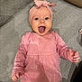 Charlotte a rejoint le concours — aidez-le/la à gagner de superbes lots ! baby, child, pink_dress, headband, tongue_out, happy, smiling, lying_down, carpet, patterned_carpet, cute, infant, playful, indoors, person, toddler, long_sleeve, fashion, portrait, expression