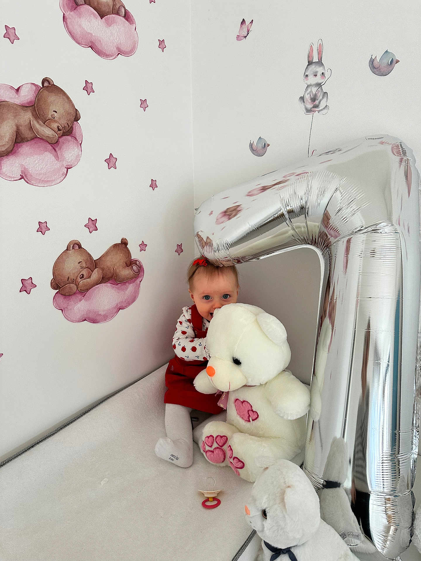 Charlotte participe au concours pour gagner de l'argent avec cette photo : baby, balloon, bed, bunny, child, cute, indoor, infant, number_one, nursery, pacifier, plush, portrait, red_dress, sitting, smile, stars, stuffed_animal, teddy_bear, wallpaper