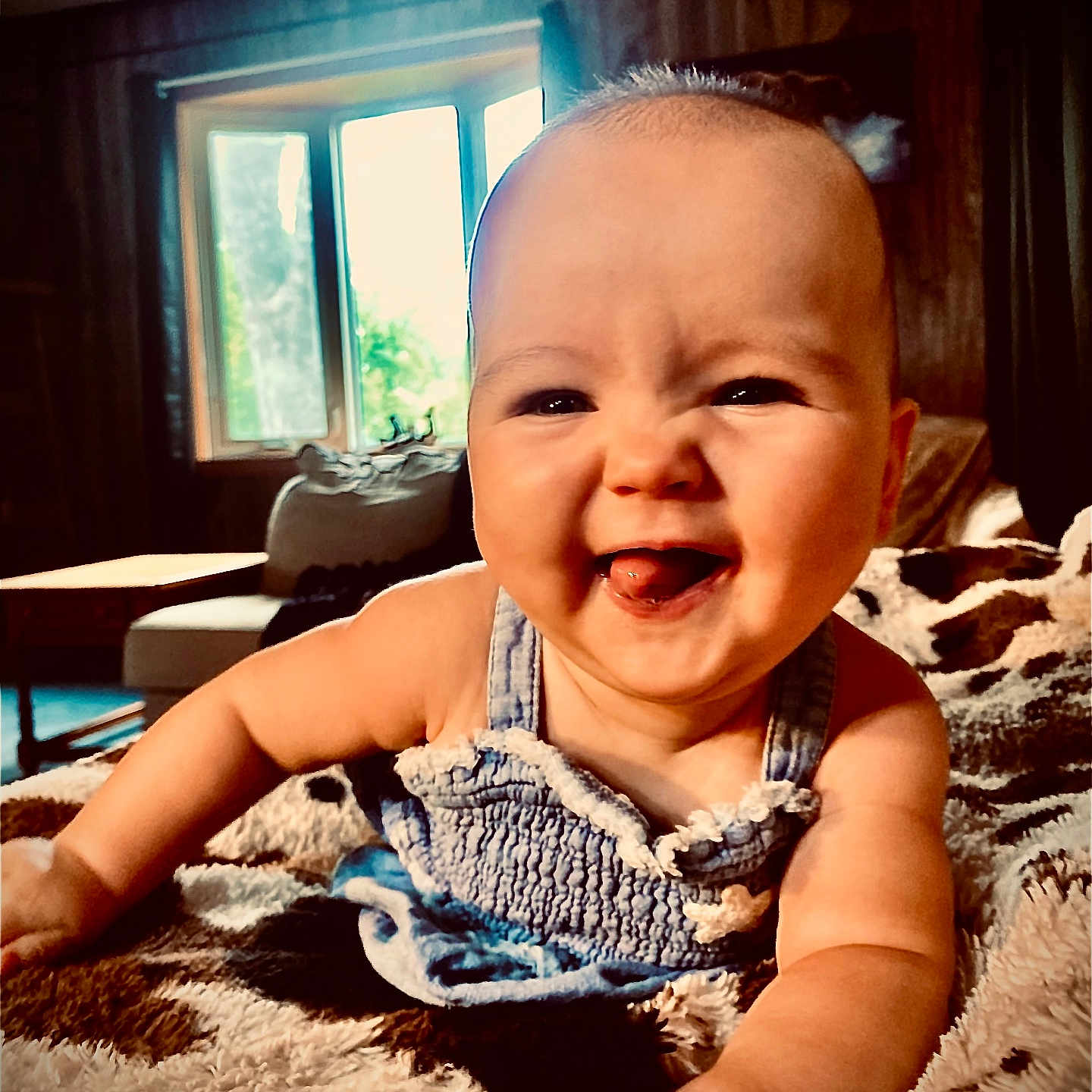 Penelope Grace joined the competition — help win amazing prizes! baby, blanket, blue_dress, child, clothing, cozy, crawling, cute, furniture, happy, home, indoor, infant, natural_light, person, portrait, smiling, tongue_out, window, wood_paneling