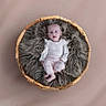 baby, basket, child, comfortable, cozy, cute, expression, floor, fur, furniture, indoor, infant, looking_up, neutral_background, pink_pants, portrait, sitting, small, soft, white_clothing
