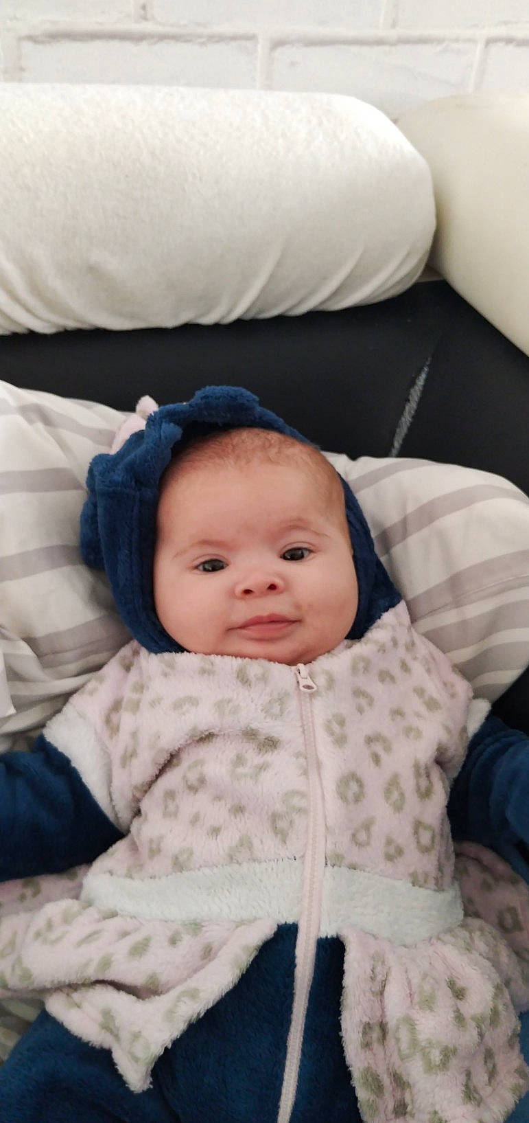 Lea participe au concours pour gagner de l'argent avec cette photo : baby, baby_toddler_clothing, cheek, child, collar, comfort, face, happy, linens, person, sitting, sleeve, smile, textile, toddler, white, winter