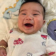 Myles joined the competition — help win amazing prizes! baby, smiling, infant, onesie, fire_truck, blanket, dinosaur, happy, cute, portrait, child, lying_down, indoors, baby_clothes, cheerful, young_child, human, face, baby_bracelet, playful