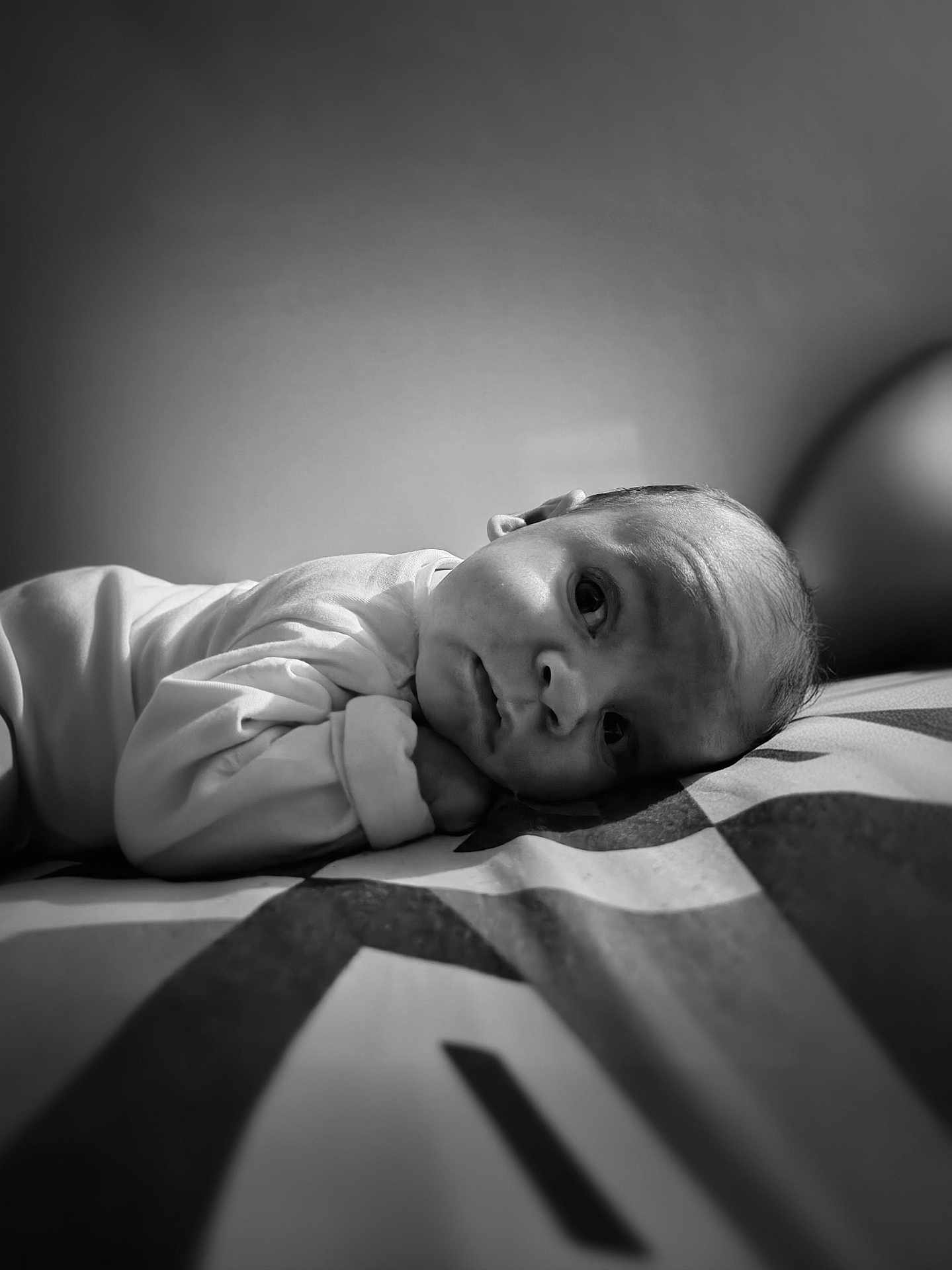 Iliano a rejoint le concours — aidez-le/la à gagner de superbes lots ! baby, infant, portrait, black_and_white, soft_lighting, close_up, face, expression, lying_down, clothing, patterned_bed, newborn, cute, peaceful, indoor, person, skin, head, eyes, young_child