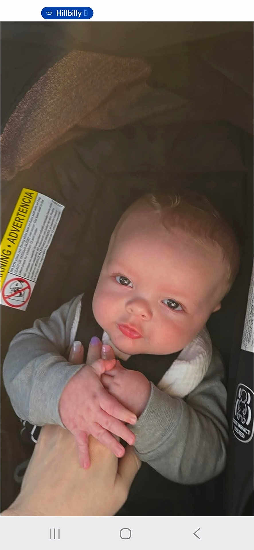 James joined the competition — help win amazing prizes! baby, infant, car_seat, hand, holding, child, cute, face, skin, clothing, seat, safety_label, person, young, looking, expression, indoor, human, childhood, toddler