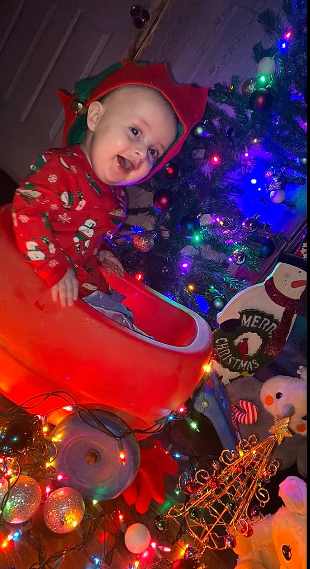 Brian is registered to the contest to win money with this photo: automotive_lighting, christmas, christmas_decoration, christmas_eve, christmas_ornament, christmas_tree, electric_blue, event, fun, holiday, holiday_ornament, light, lighting, magenta, ornament, person, pink, purple, smile, space