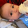 Brantley is registered to the contest to win money with this photo: baby, beverage, blanket, bodypart, bottle, clothing, cream, dairy, drinking, face, finger, food, hand, head, milk, newborn, person, photography, portrait, t_shirt