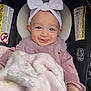 baby, child, smiling, headband, bow, blanket, car_seat, clothing, pink, face, infant, cute, happy, indoors, person, portrait, seat, warning_label, soft, toddler
