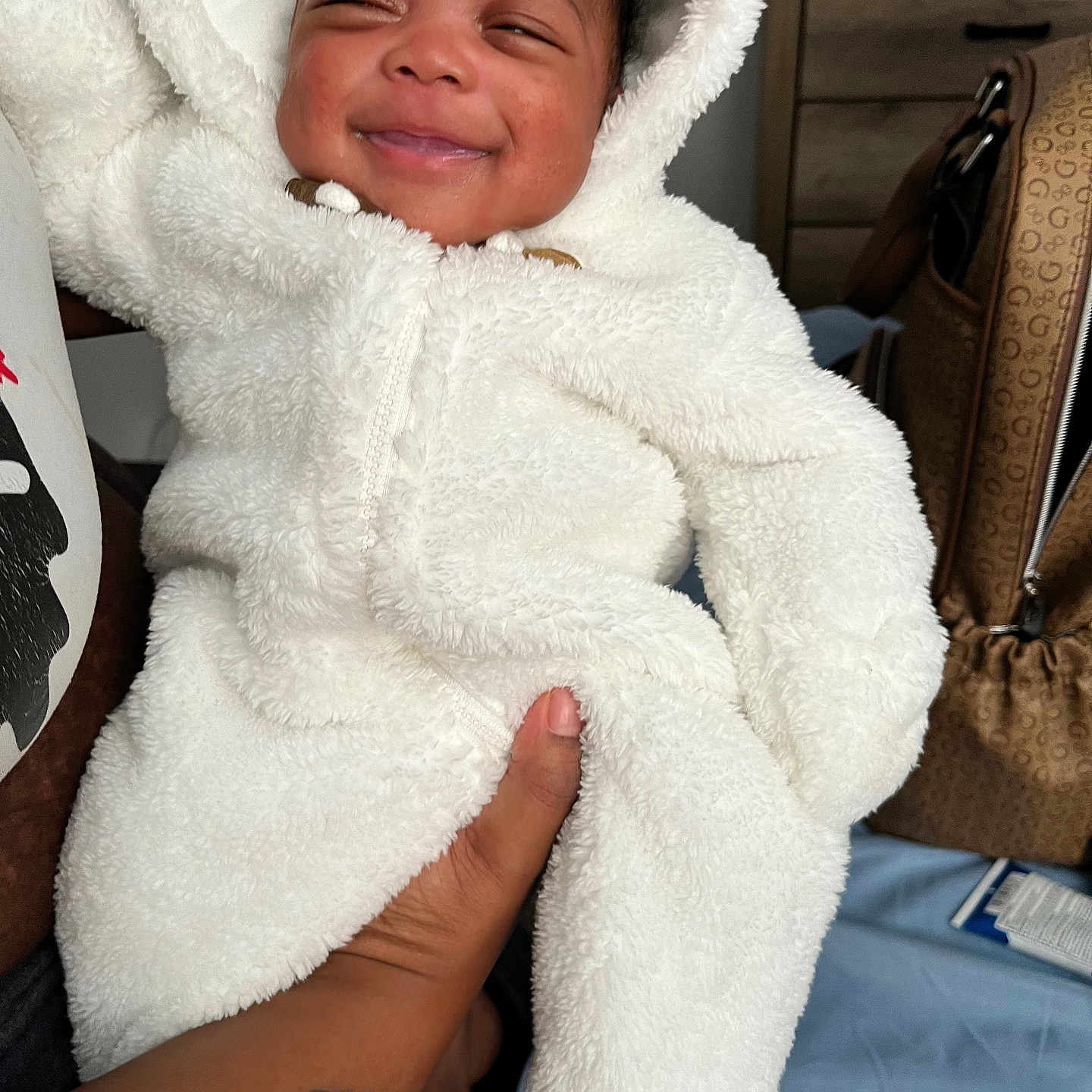 Zanayla is registered to the contest to win money with this photo: accessories, baby, bag, blanket, bodypart, clothing, face, handbag, happy, hat, head, hoodie, knitwear, person, photography, portrait, smile, sweater, sweatshirt, towel