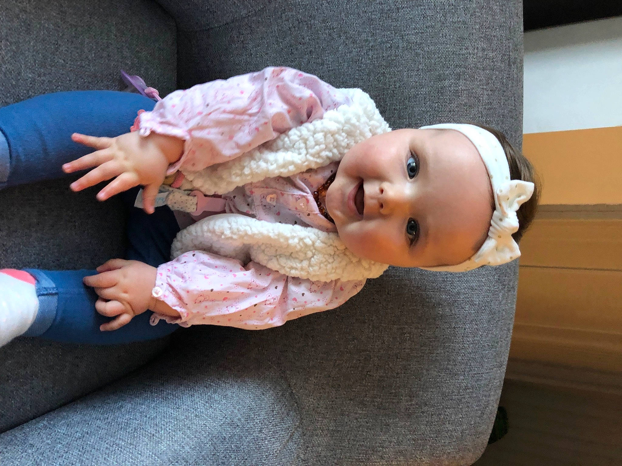 Alice participe au concours pour gagner de l'argent avec cette photo : baby, baby_products, baby_toddler_clothing, cheek, comfort, eye, finger, gesture, hand, headgear, headwear, human_body, human_leg, lap, person, sitting, skin, sleeve, sock, toddler