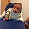 Genesis joined the competition — help win amazing prizes! baby, high_chair, bib, curious, child, indoor, table, hand, face, young, person, clothing, wooden_door, expression, skin, looking, sitting, furniture, home, infant