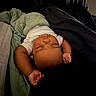 baby, sleeping, blanket, bed, arms, peaceful, infant, child, resting, comfort, dark_background, white_clothing, close_up, indoor, skin, portrait, relaxation, young_child, cozy, toddler